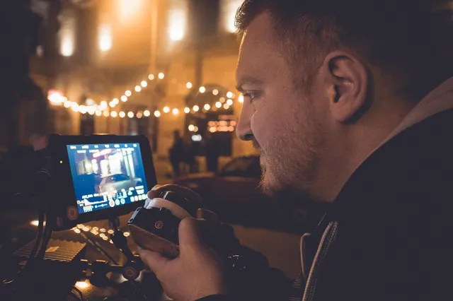 View of the field monitor during the night shoot, string lights in the background