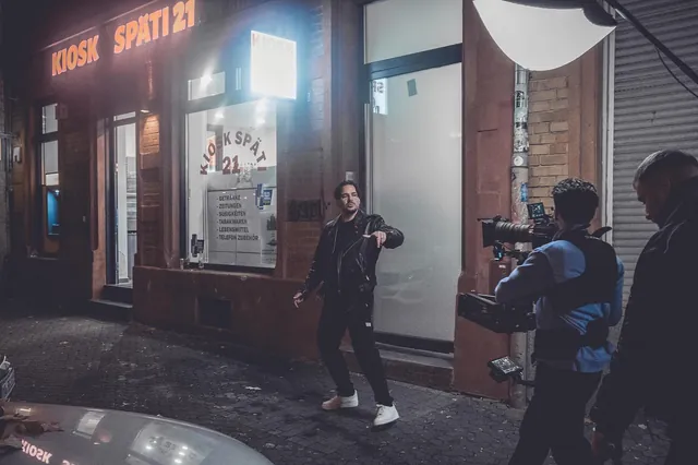 Night shoot outside a kiosk: camera operator with a Steadicam filming the performer
